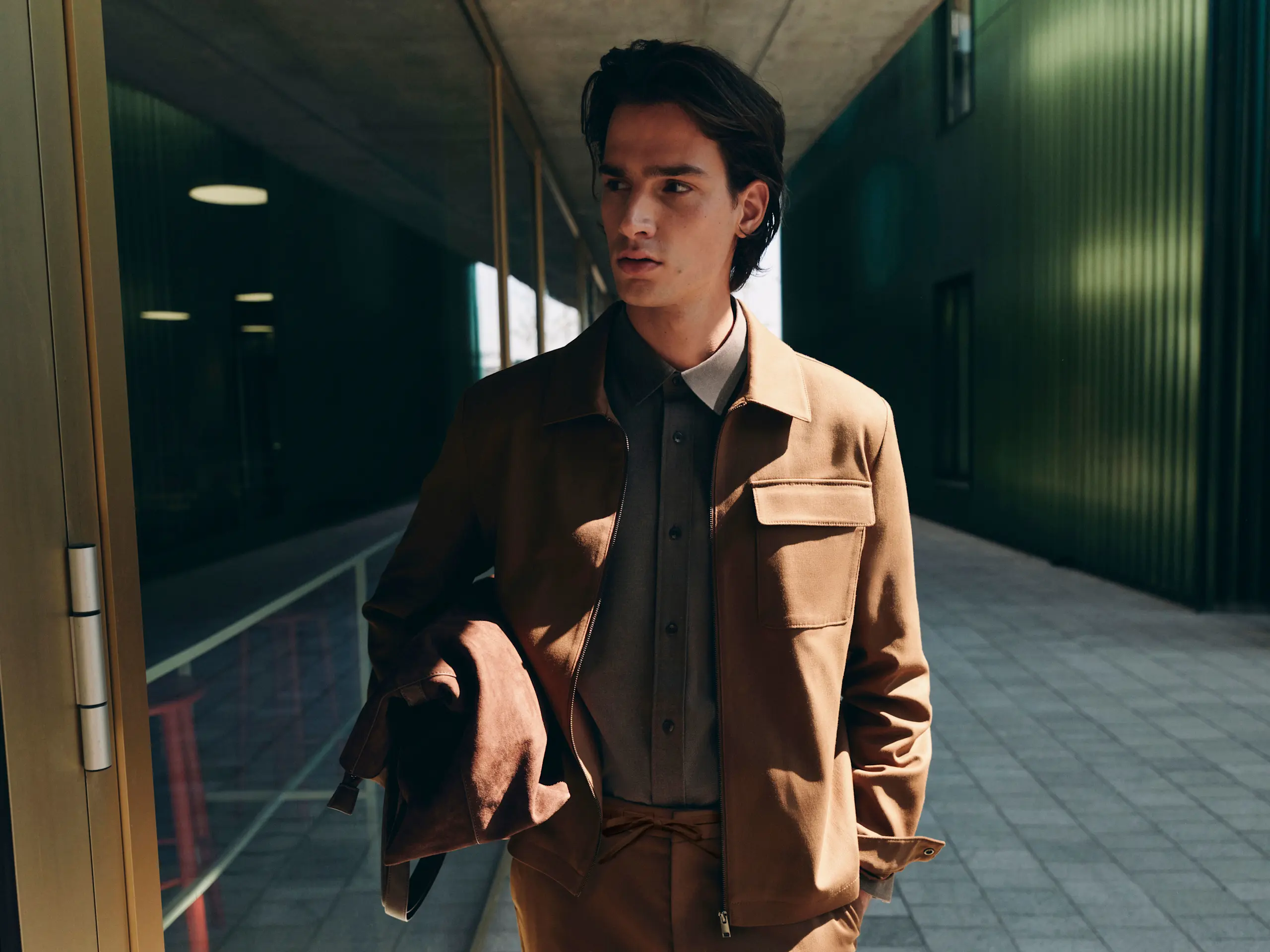 Man wearing brown jacket over a shirt and matching brown trousers