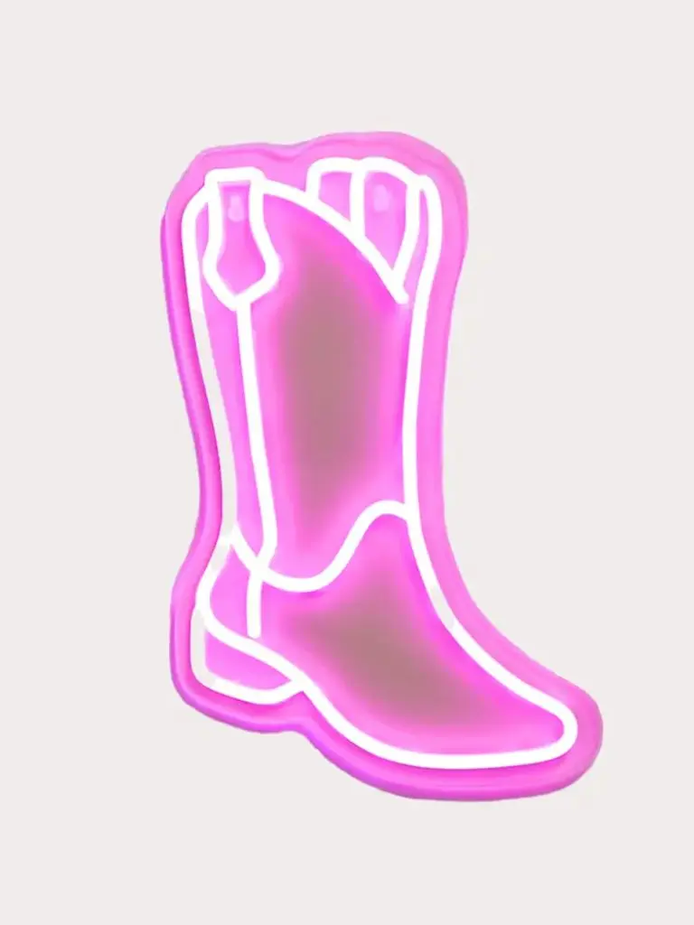 A cutout of a neon cowboy boot lamp against a pale background