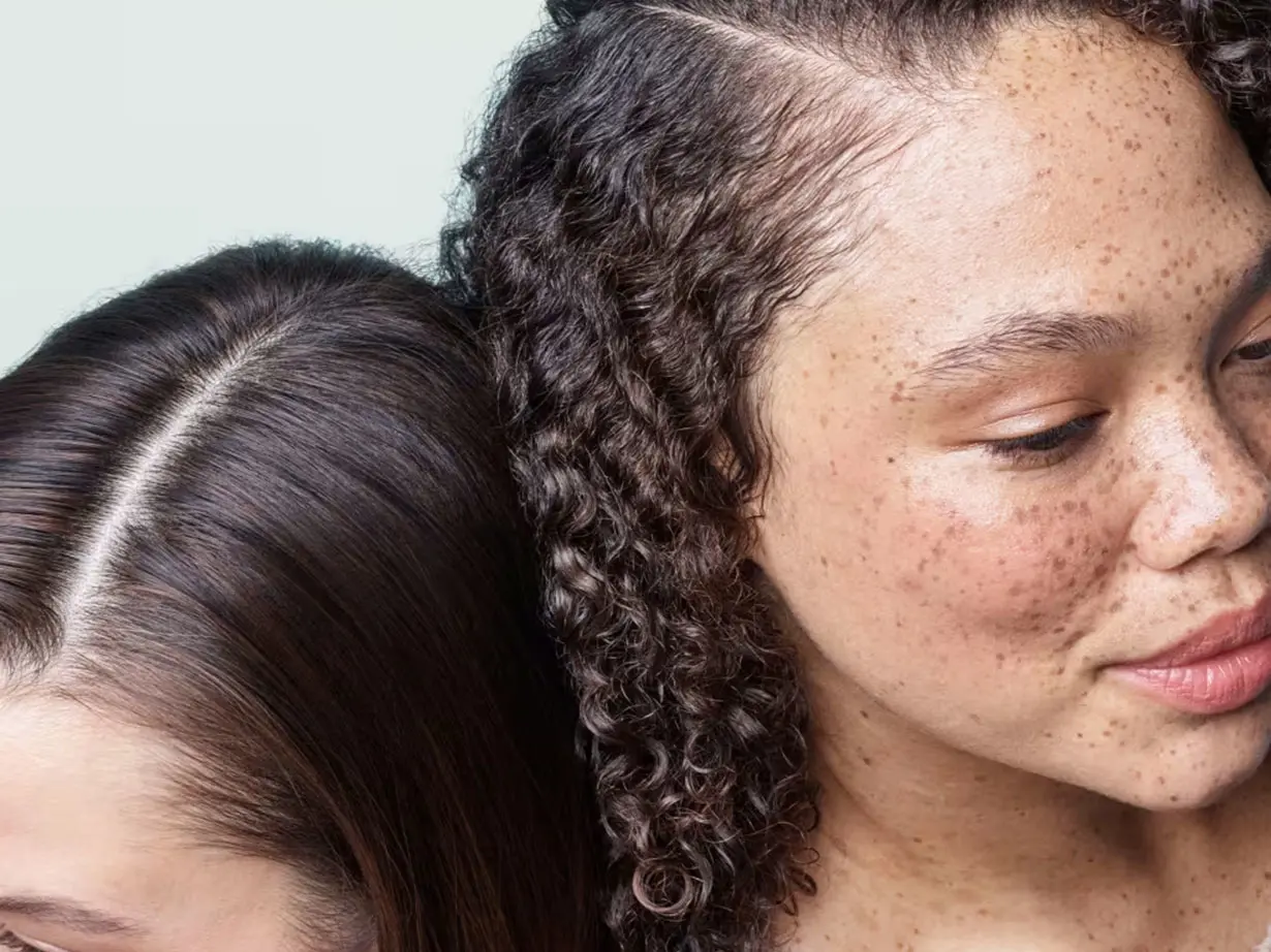 Woman with straight hair beside a woman with curly hair