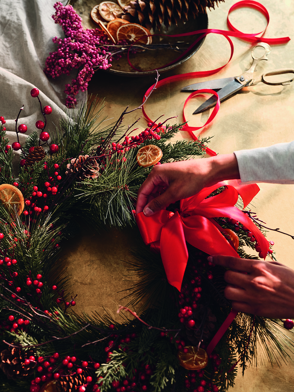 Woman decorating a Christmas wreath 