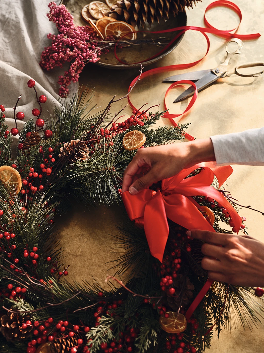 Woman decorating a Christmas wreath 