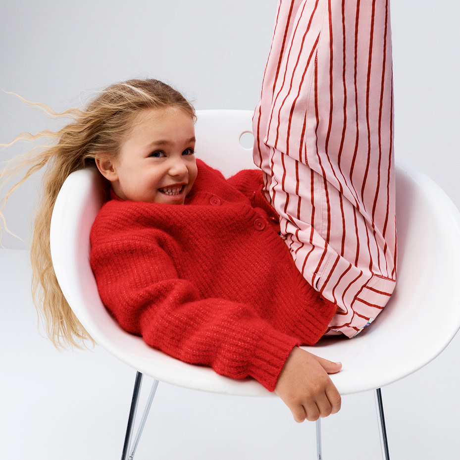 Girl wearing red jumper and striped trousers