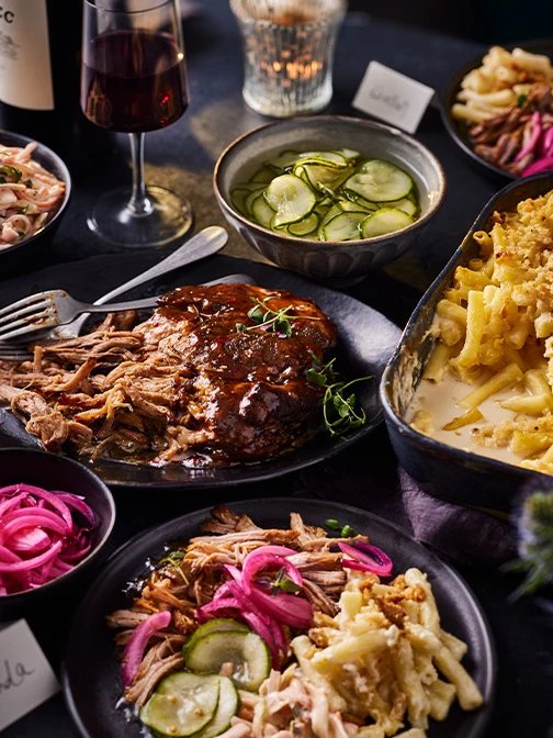Pulled pork, mac and cheese, and bowl of pickes