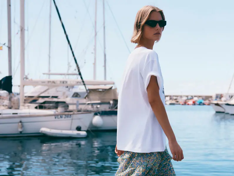 Woman wearing an oversized white T-shirt and black sunglasses