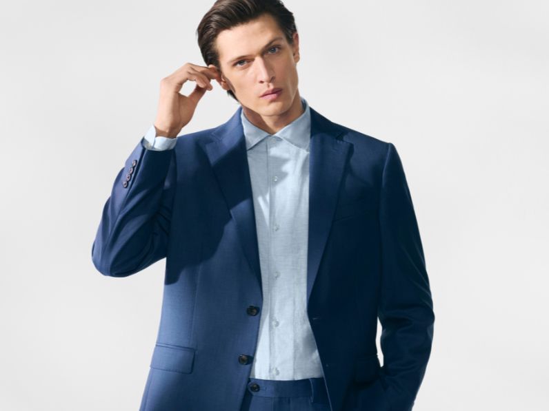 Man wearing navy Jaeger suit with light blue shirt