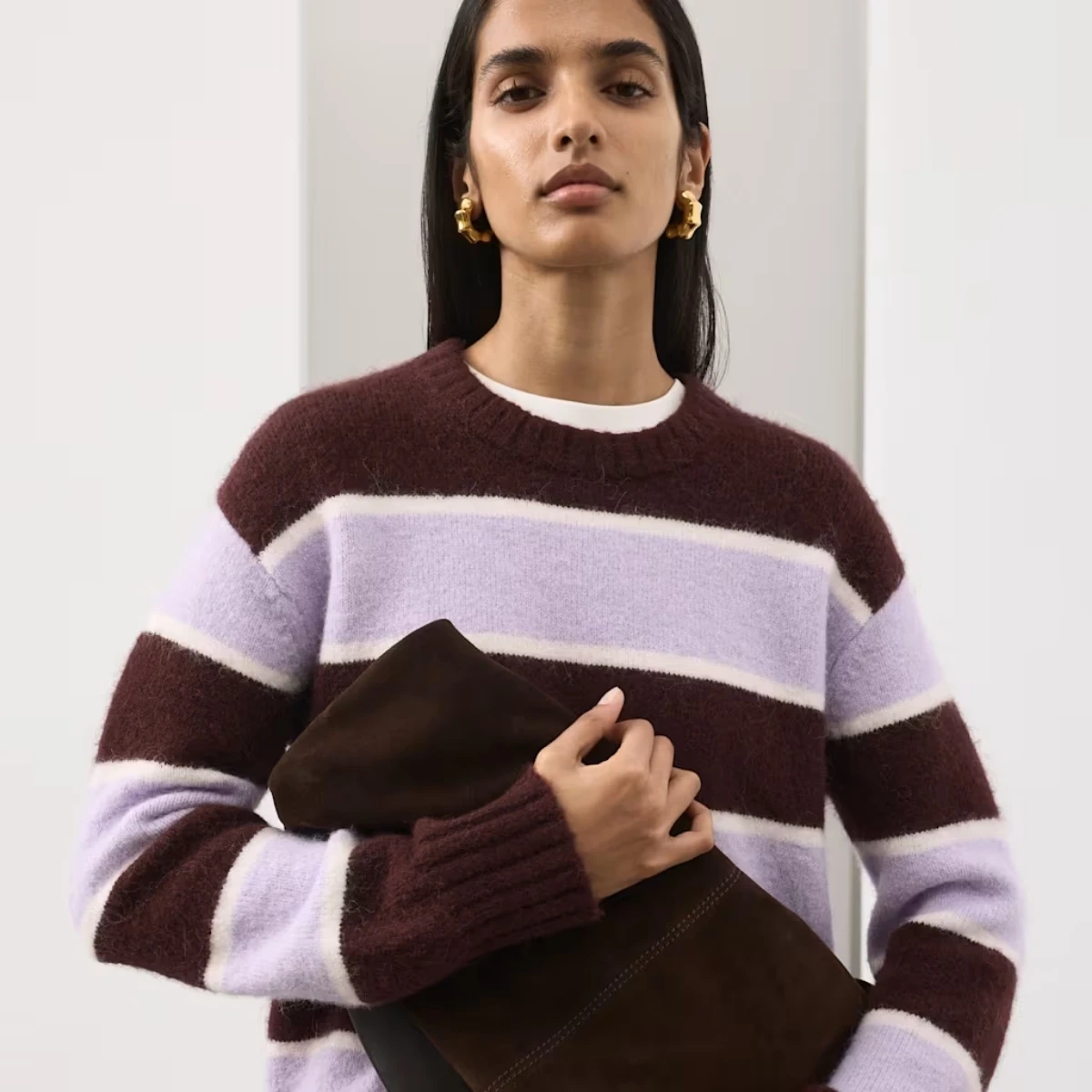 A woman wears a lilac and burgundy stripe jumper by Autograph