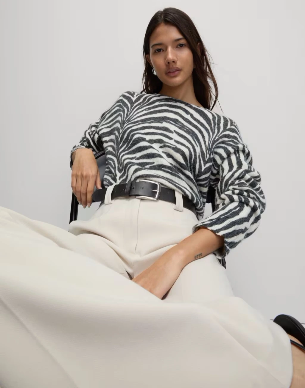 Woman wearing zebra-print jumper and white jeans at M&S