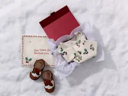 A Christmas Eve box with pyjamas, slippers and a letter to Santa sat on snow