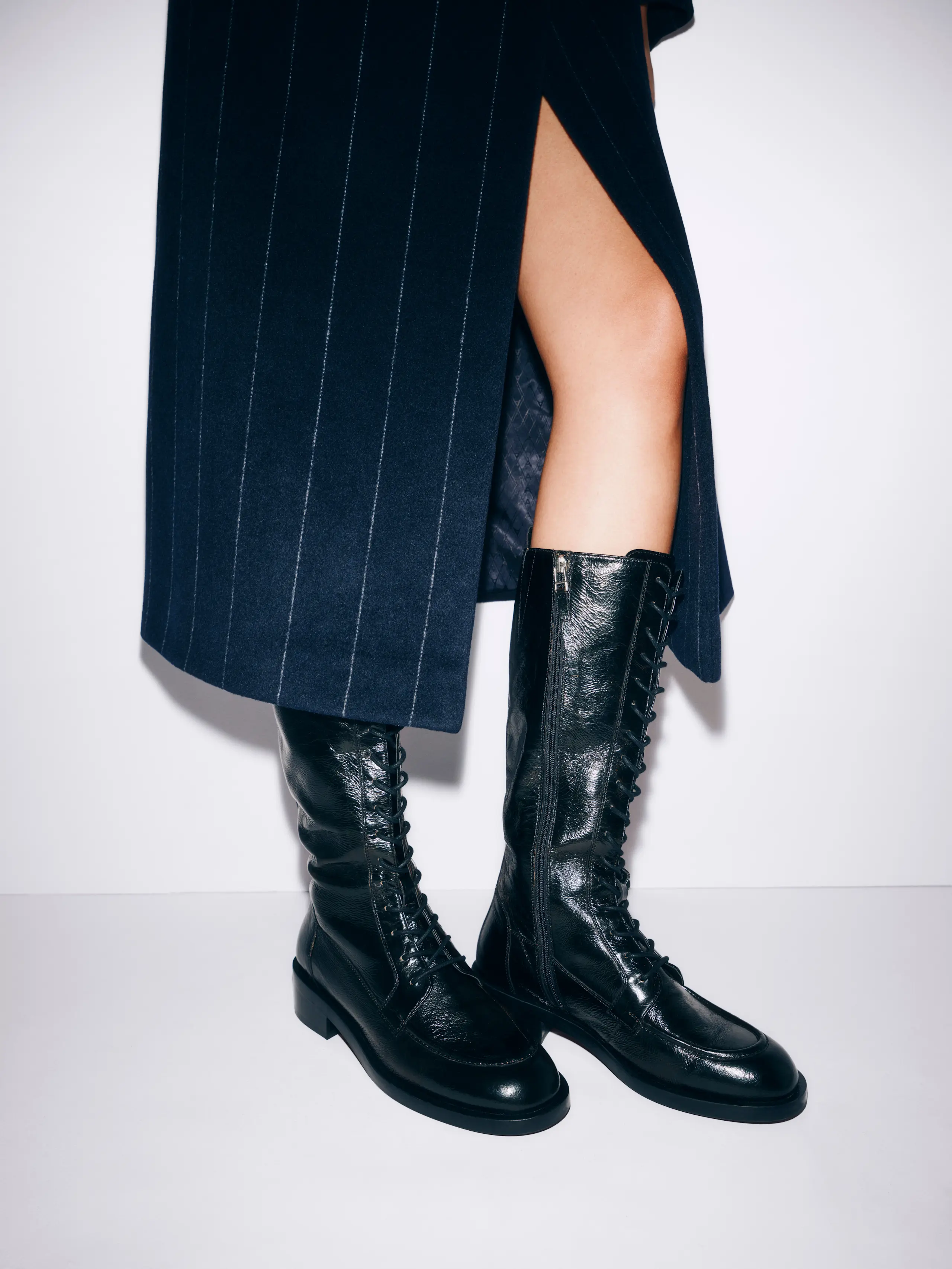 Woman wearing striped navy skirt and black lace-up boots