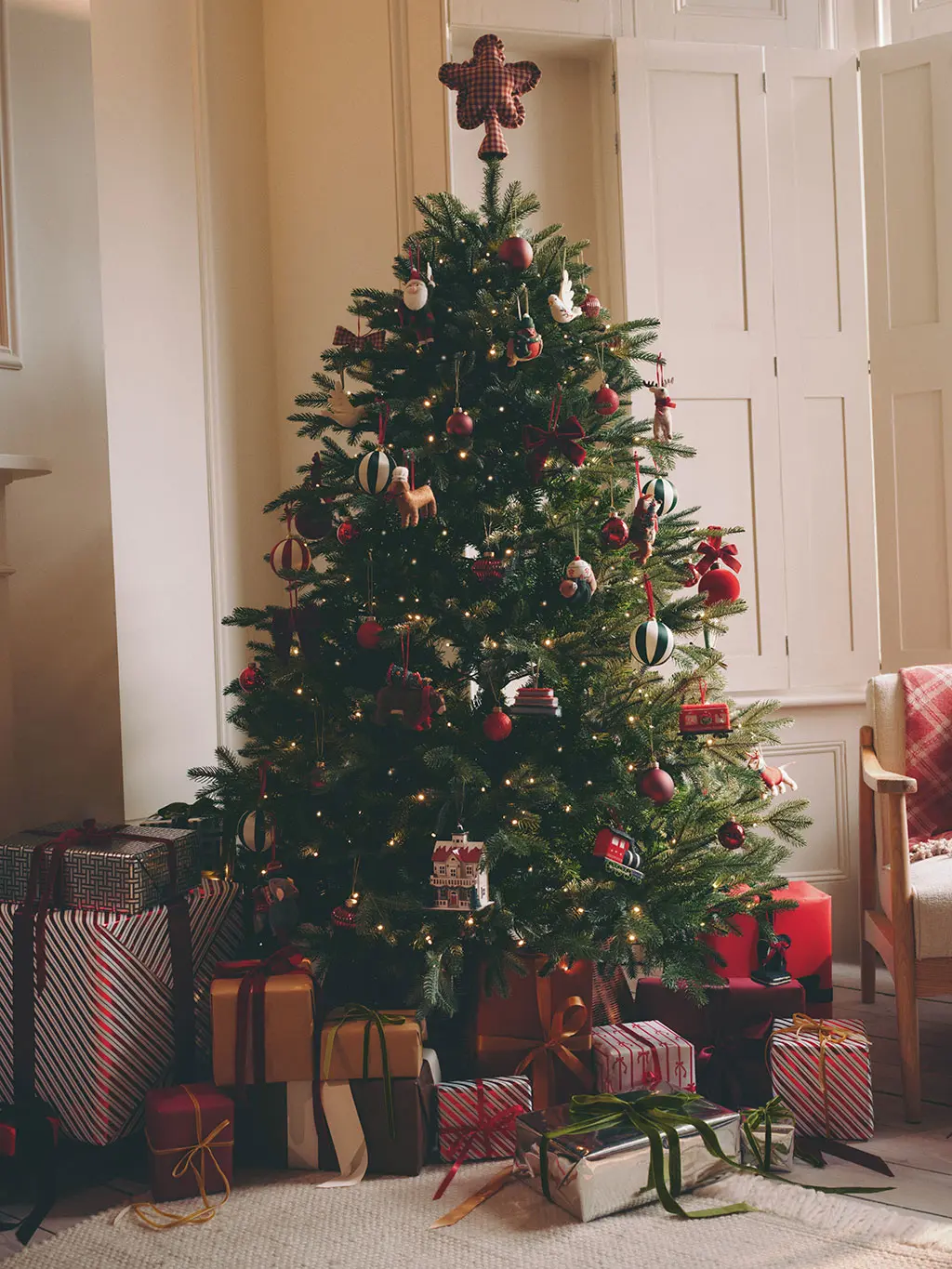 Christmas tree decorated with red decorations with presents underneath