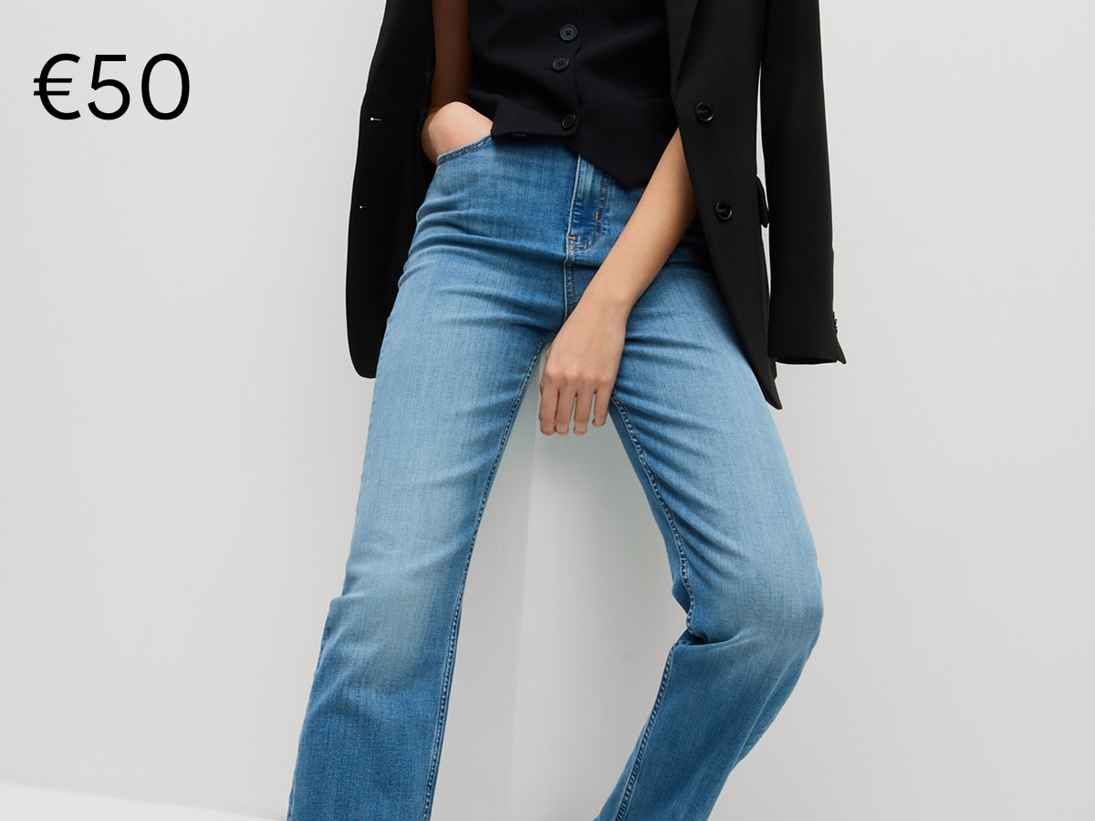 Woman wearing high waisted blue jeans with black top