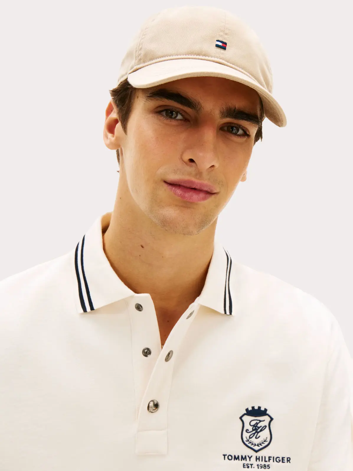 Man wearing neutral cap and polo shirt