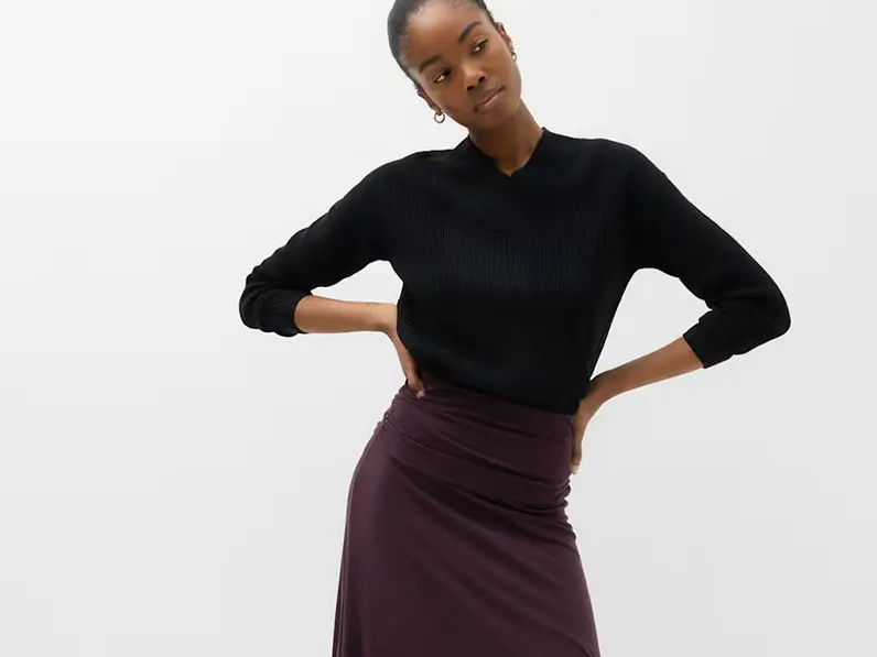 Woman in burgundy skirt and black jumper