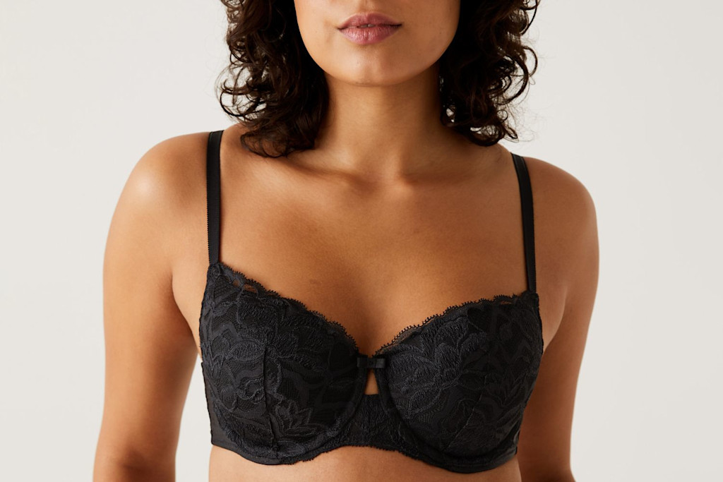 Woman wearing black lace balcony bra. Shop balcony bras