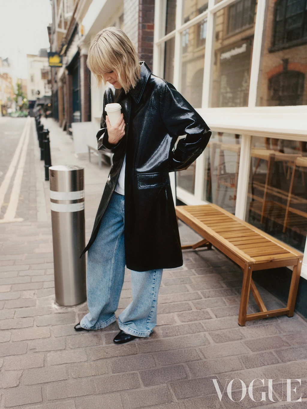 British Vogue editor Laura Ingham wearing a black patent longline coat by Autograph