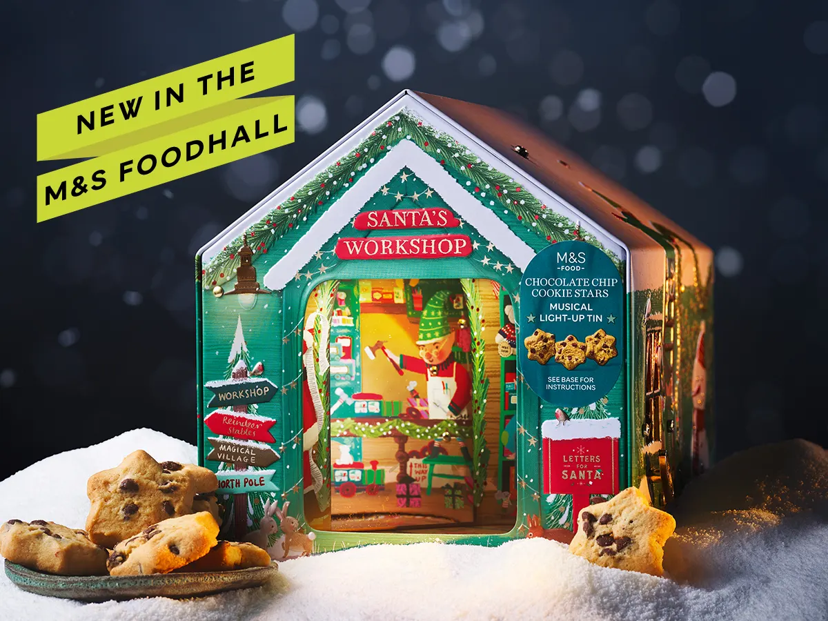 An M&S Santa's Workshop Biscuit tin on a snowy scene