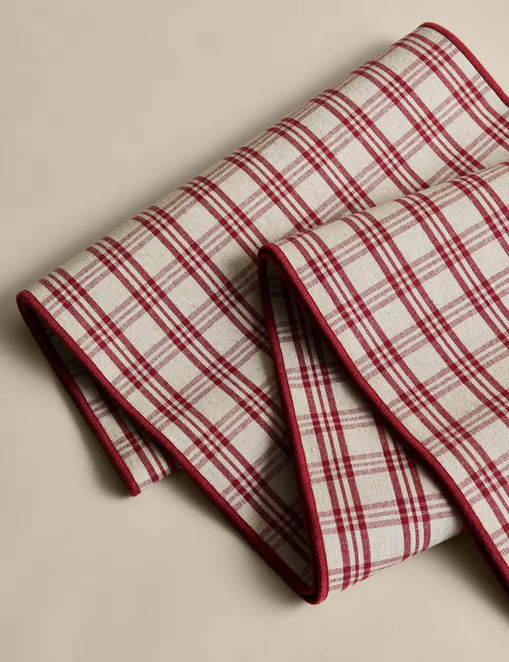 Red and beige checked table runner with a red trim.