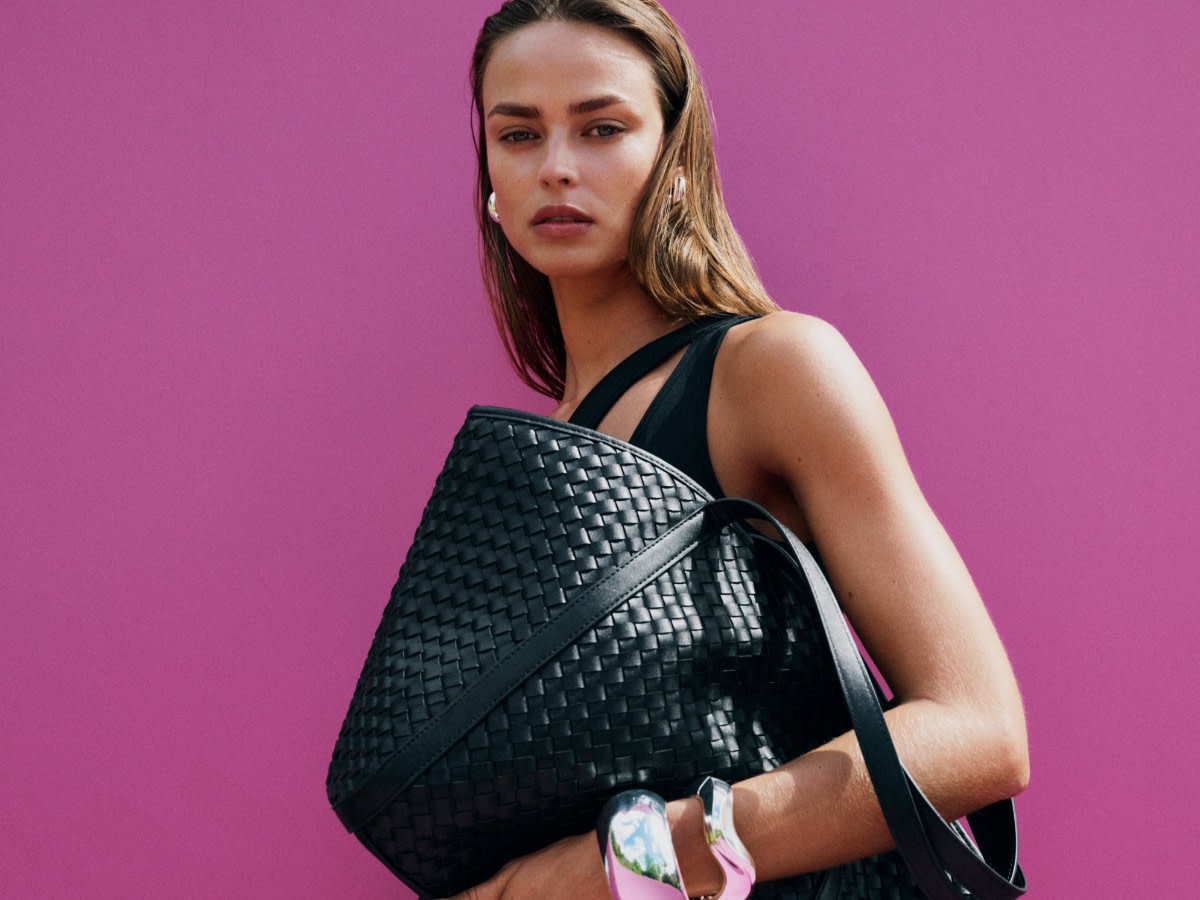 Woman holding black handbag. Shop handbags
