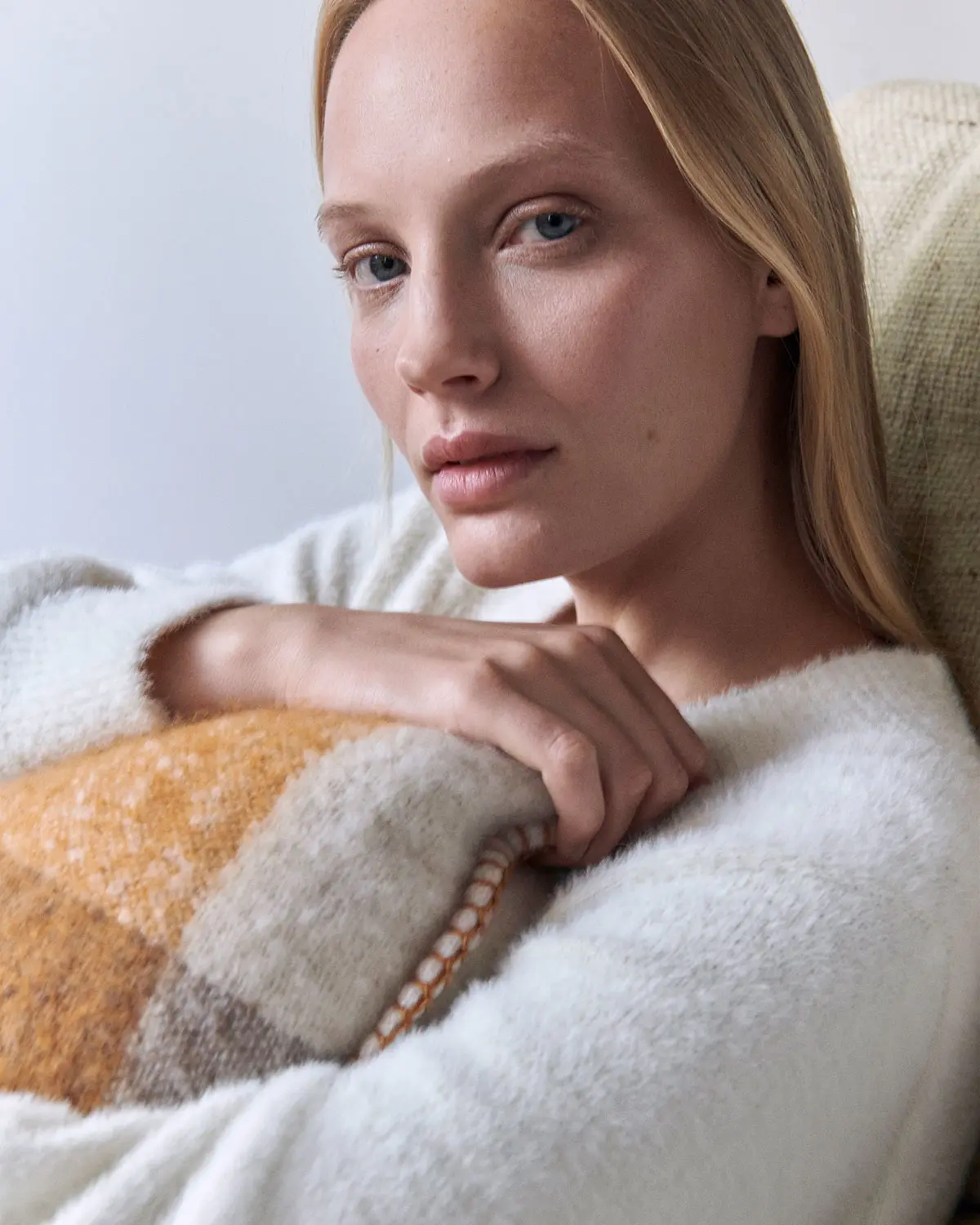 Woman in cosy sleepwear cuddling a cushion