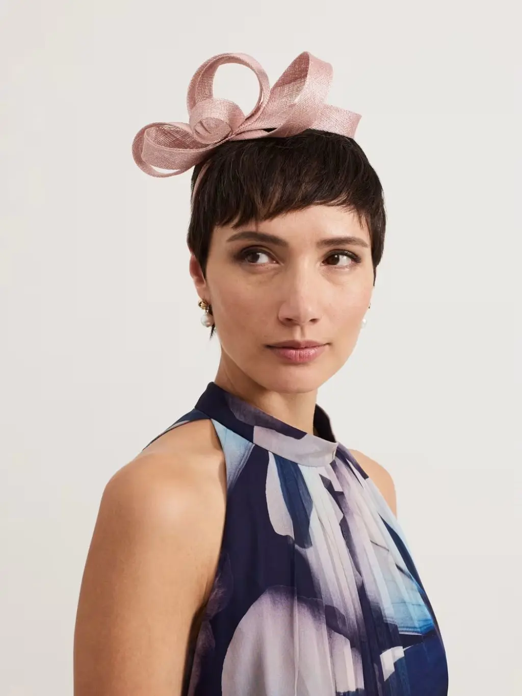 A headshot of a model with short hair wearin ga 