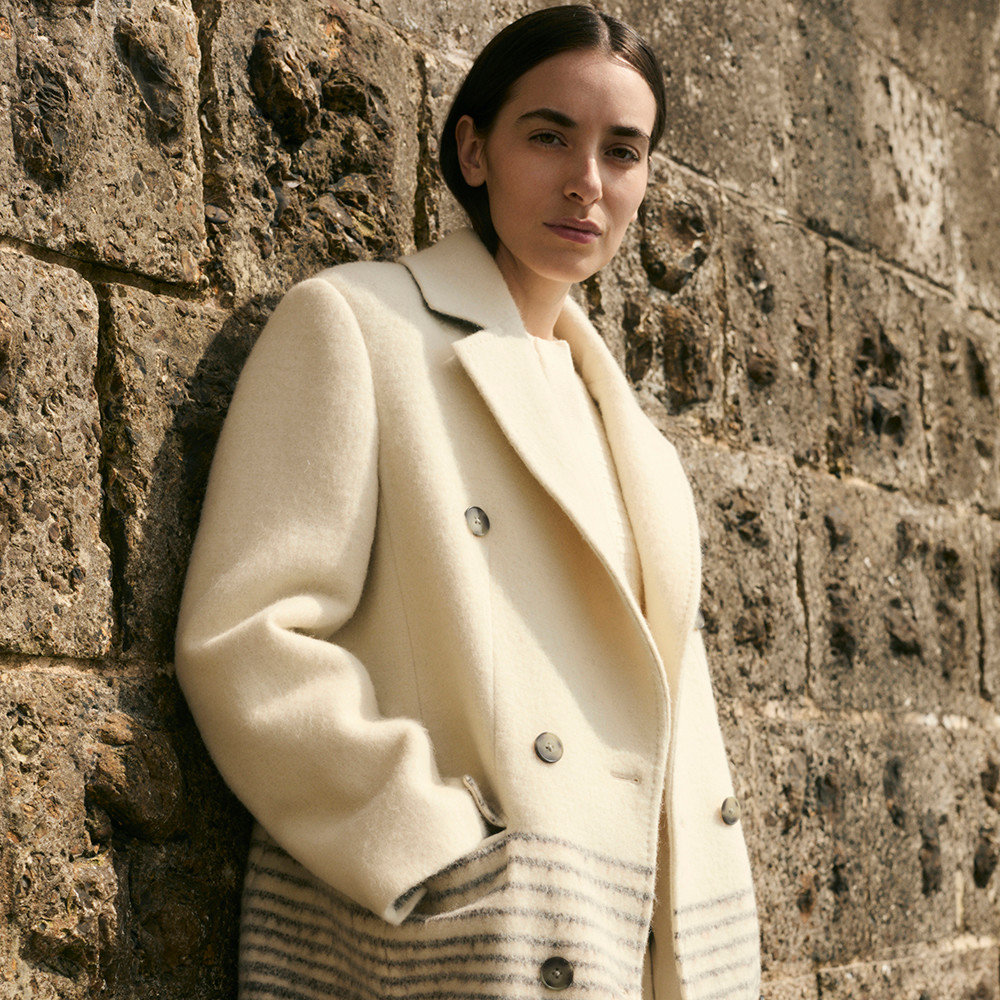 Woman wearing cream wool coat by Jaeger