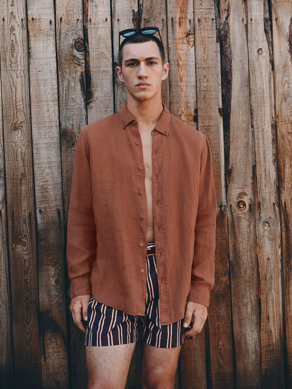 Man in brown shirt with striped shorts