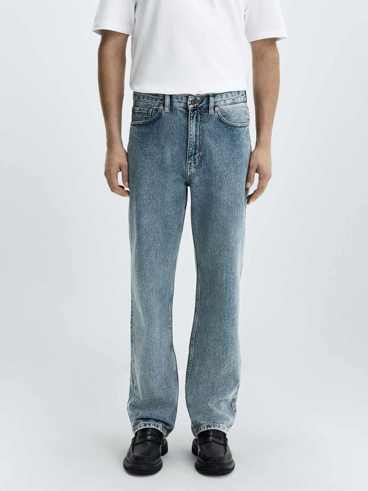 Man wearing regular fit jeans and a white T-shirt