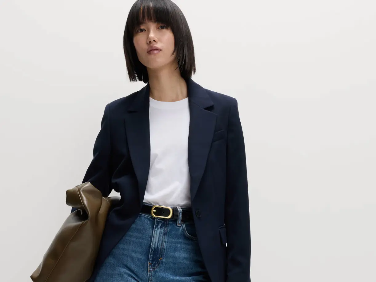 Woman wearing navy blazer over white T-shirt and blue jeans 