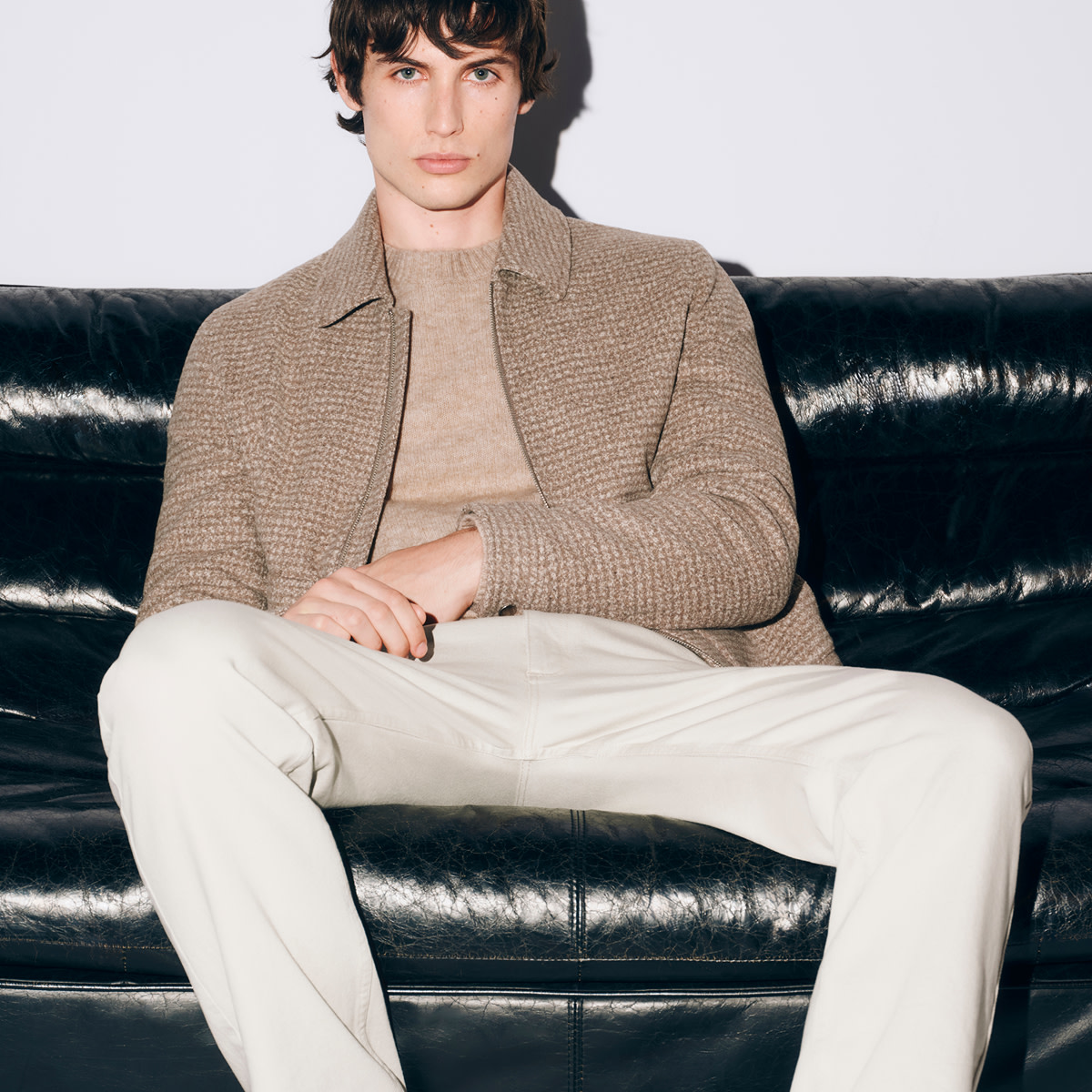 Man wearing brown jacket and ecru trousers