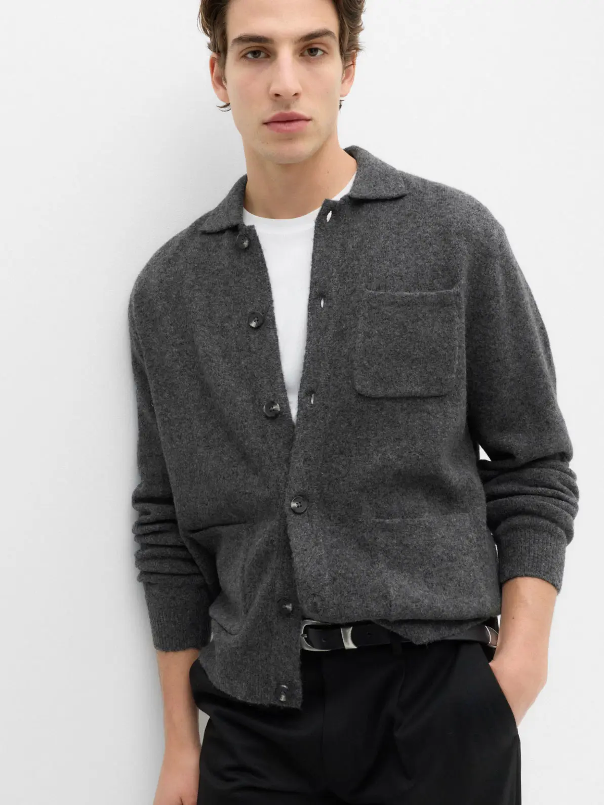 Man wearing grey cardigan over white T-shirt