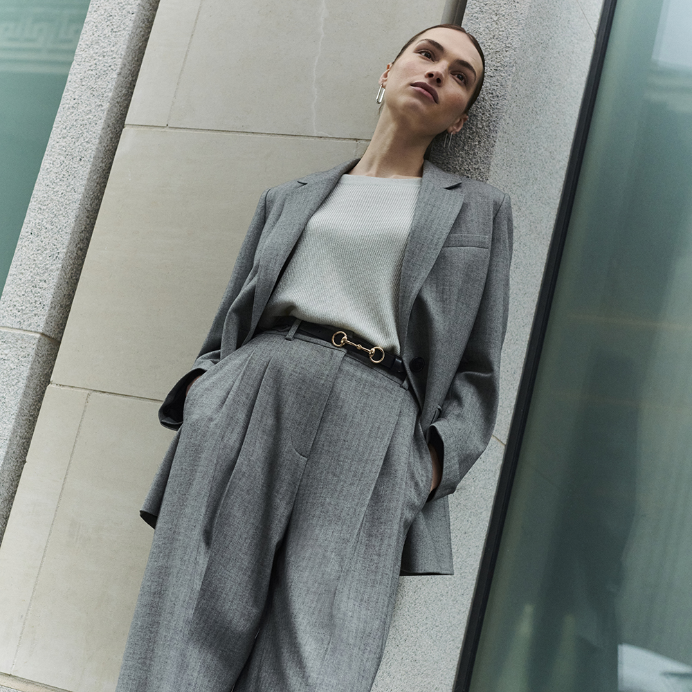 Woman wearing grey herringbone suit