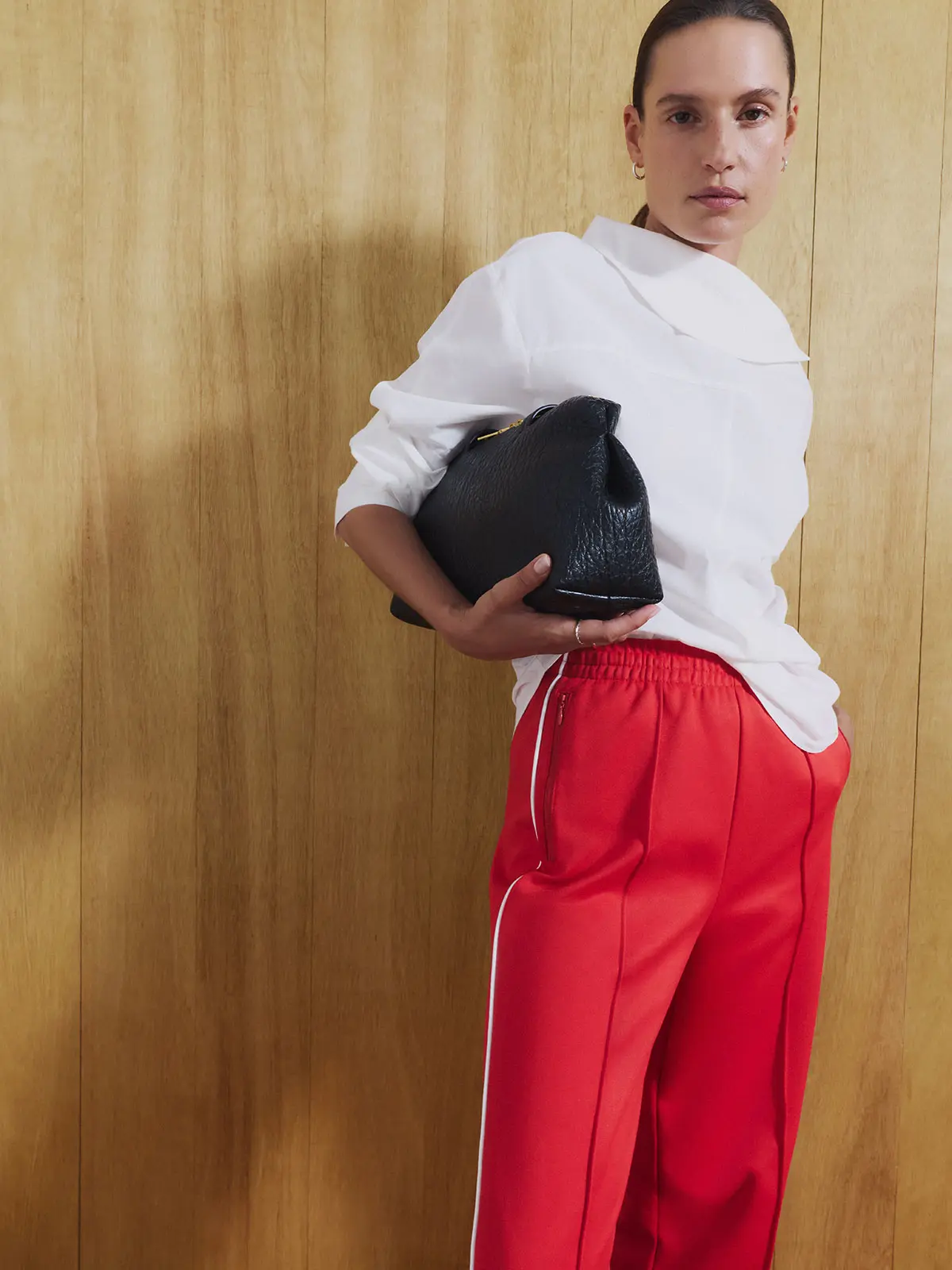 Woman wearing white top and red casual trousers