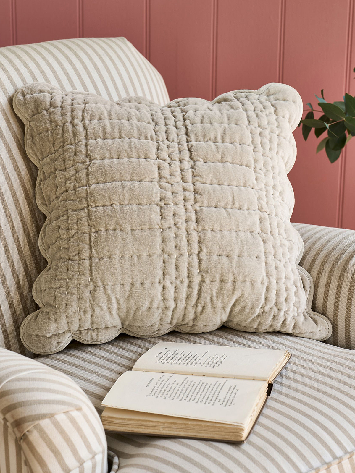Cream cushion and book on striped chair