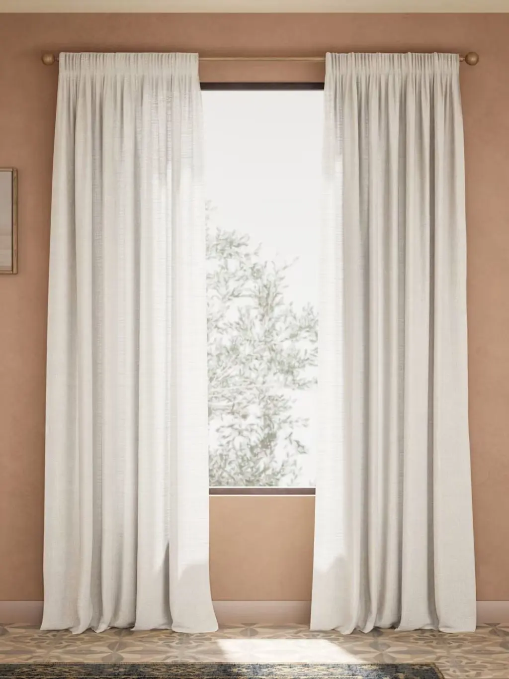 A window in a neutral wall with beige sheer curtains hanging