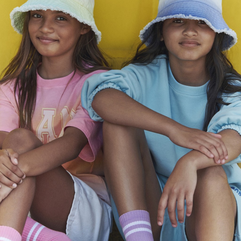 Girls wearing bucket hats, tops and shorts. Shop kids’ new in