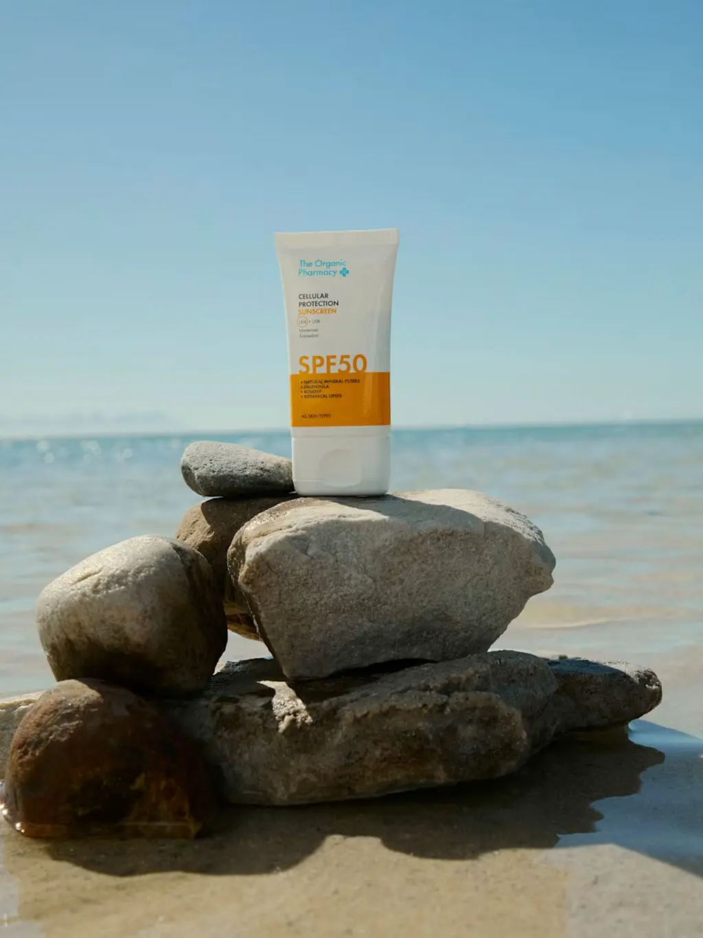 Bottle of sunscreen on beach