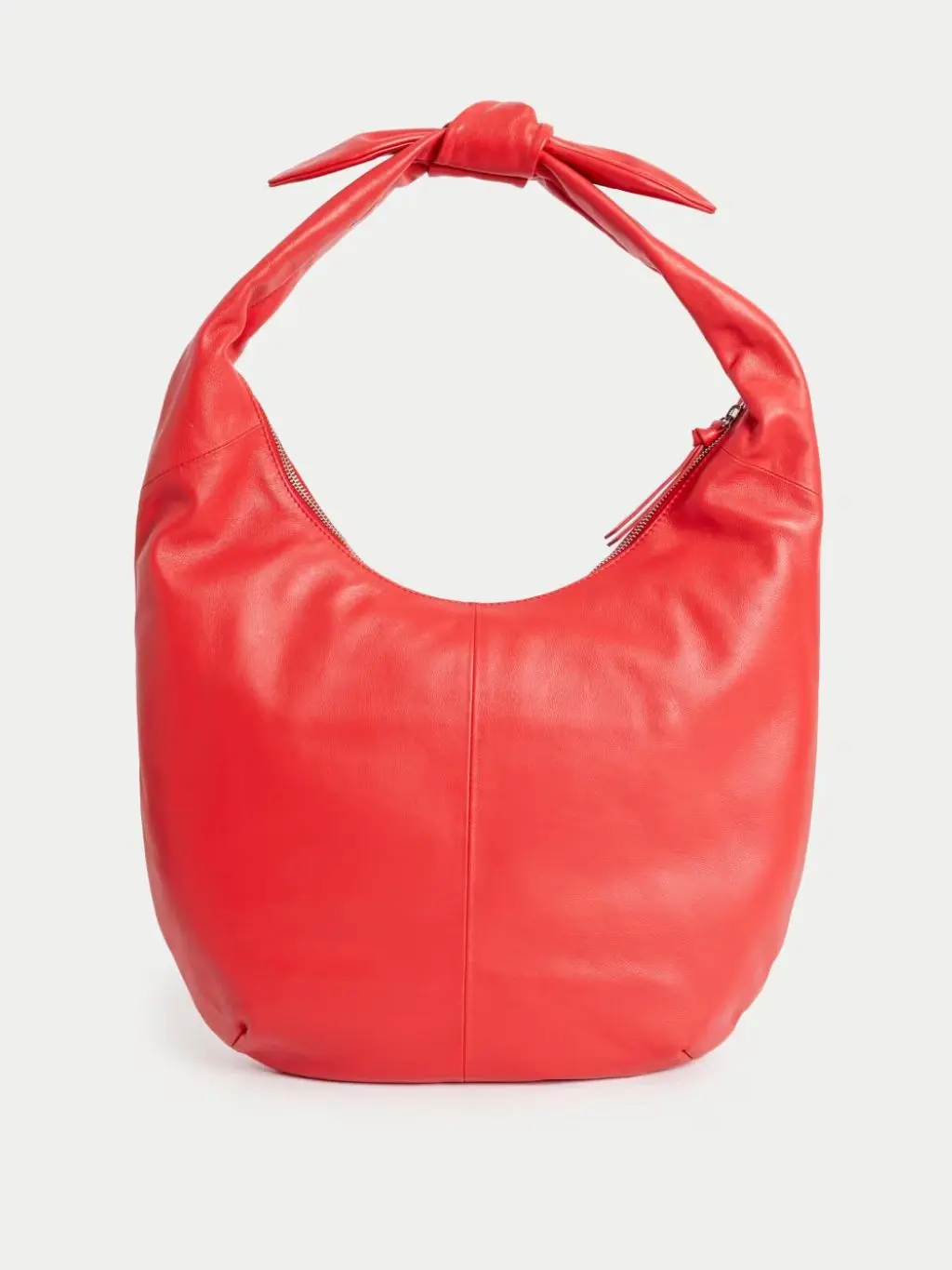 A cut out of a red leather bag against a cream background
