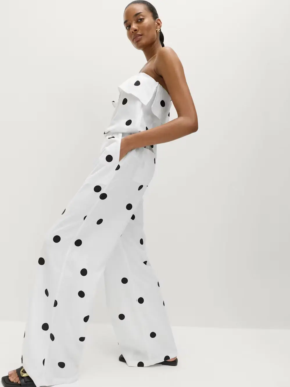 Woman in white polka dot jumpsuit