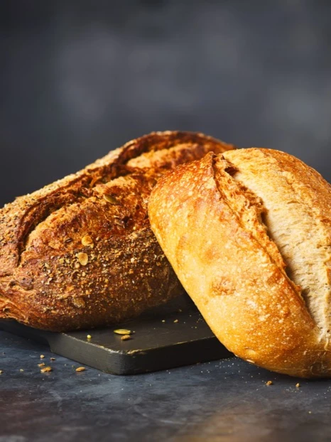 One white sourdough loaf and one seeded sourdough loaf