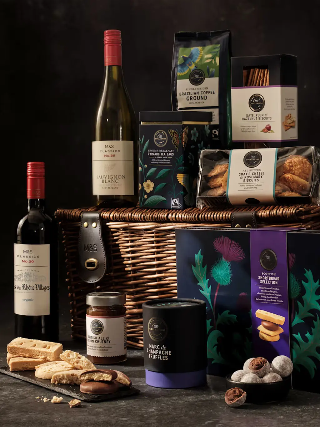 The Deluxe Hamper including white and red wine, coffee, biscuits and chocolate truffles presented in a basket.