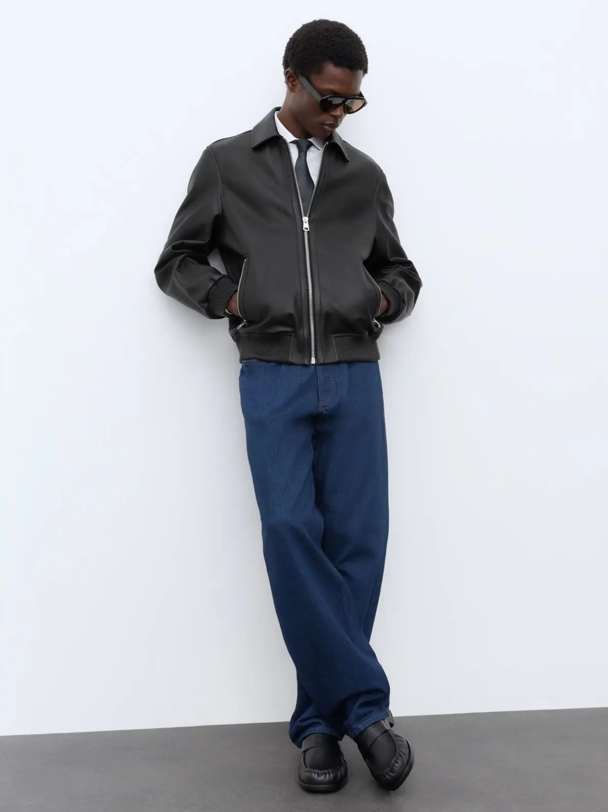 Man wearing black leather jacket and blue jeans 
