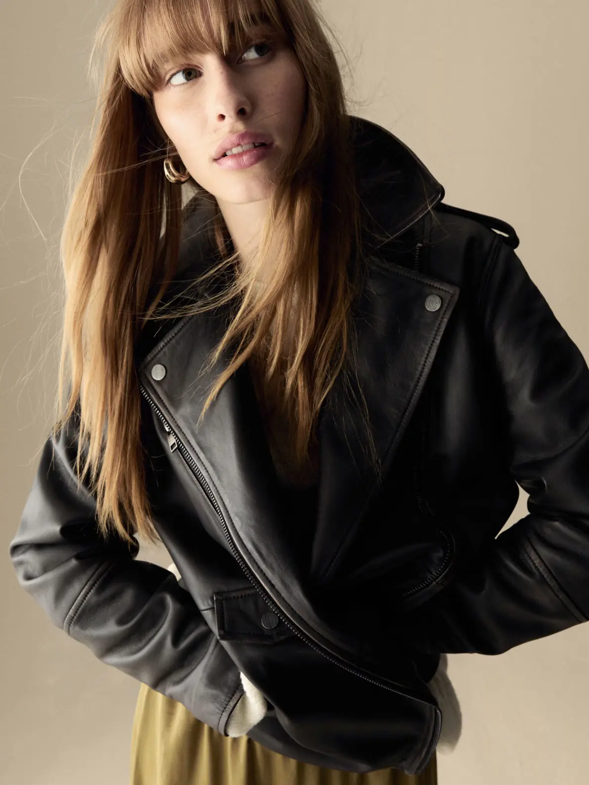 Woman wearing leather jacket over dress