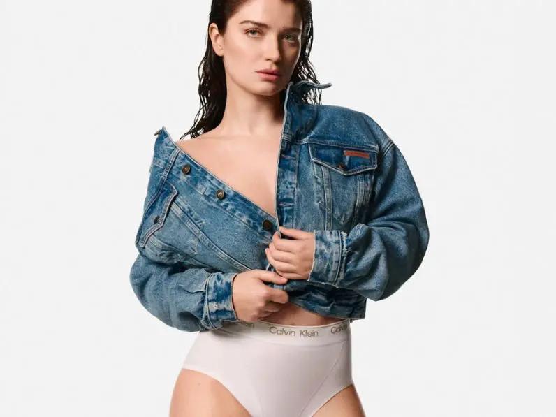 A women wears a denim jacket and Calvin Klein white knickers
