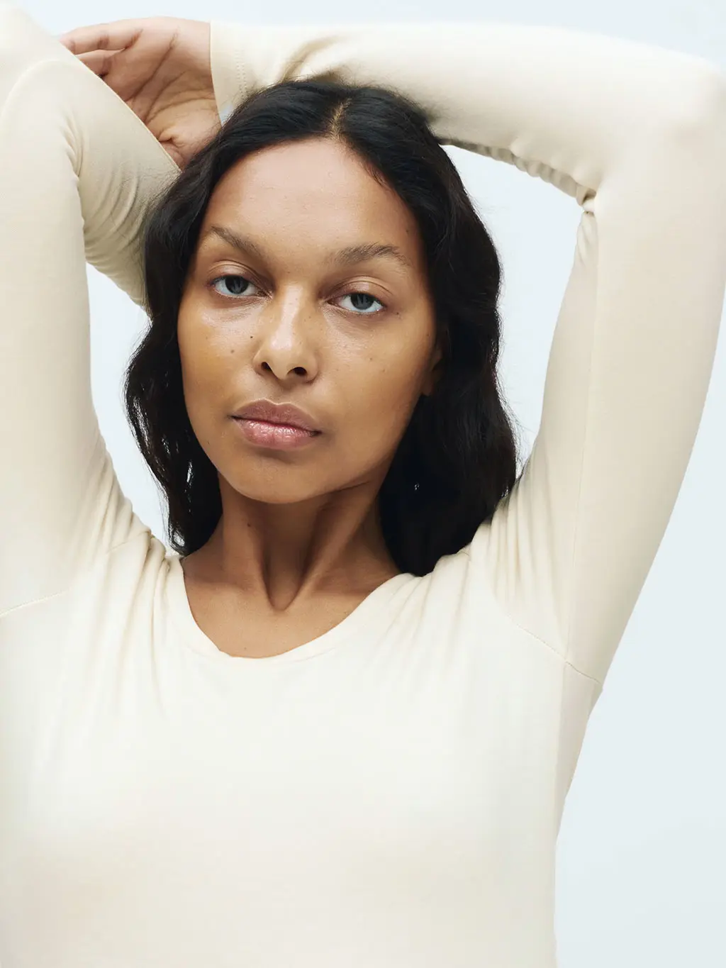 Woman wearing a light cream thermal top