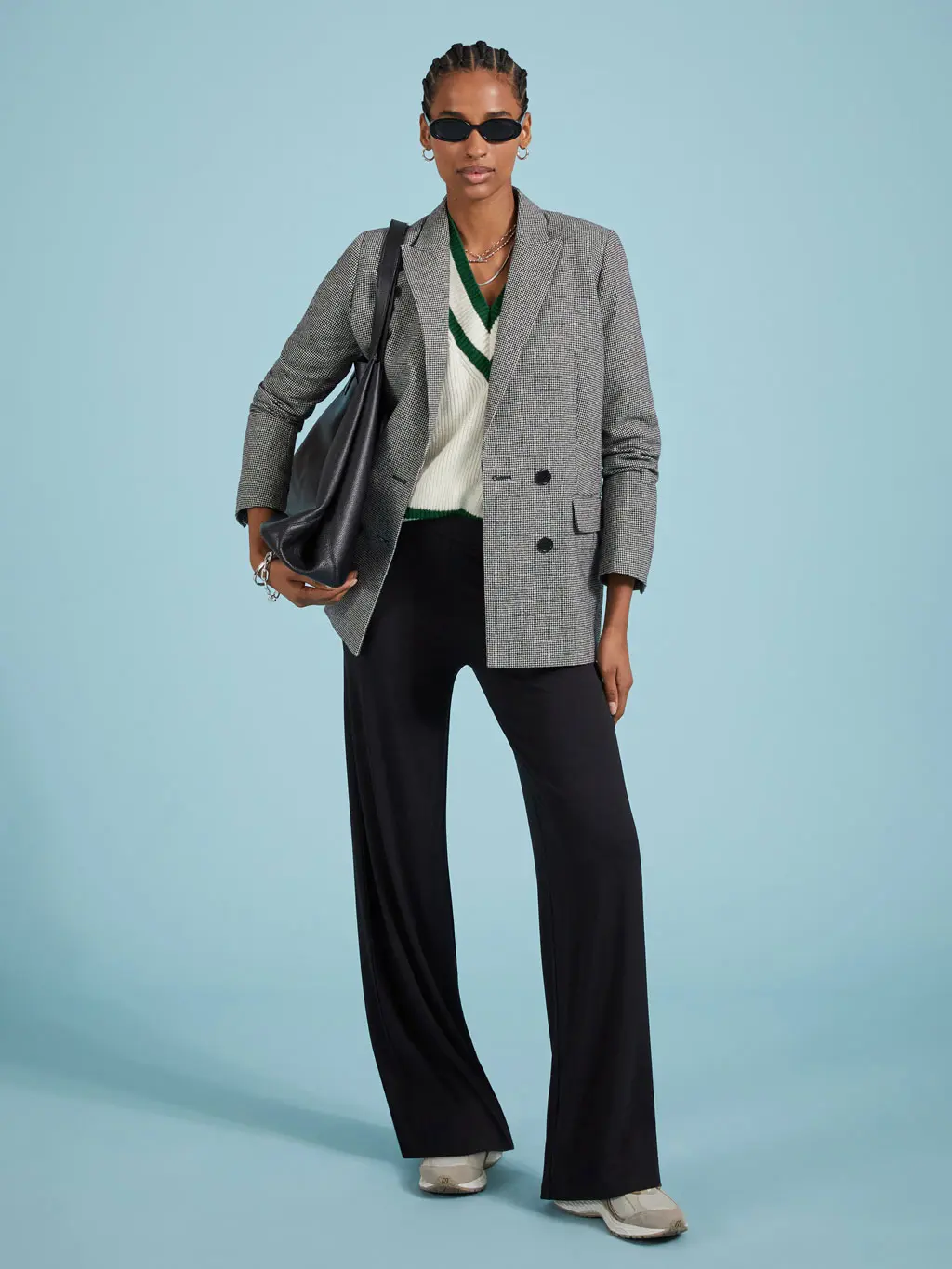 Woman wearing flared leggings, a grey blazer and cricket jumper