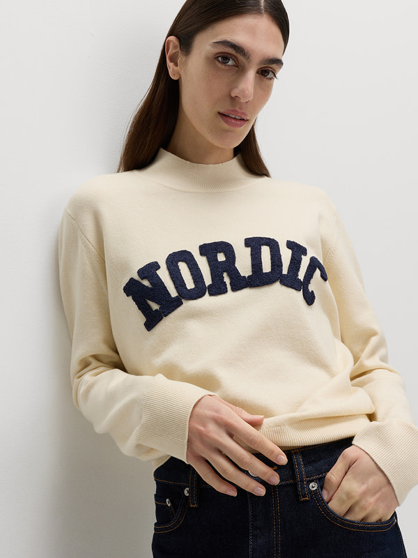 Woman wearing slogan funnel-neck jumper