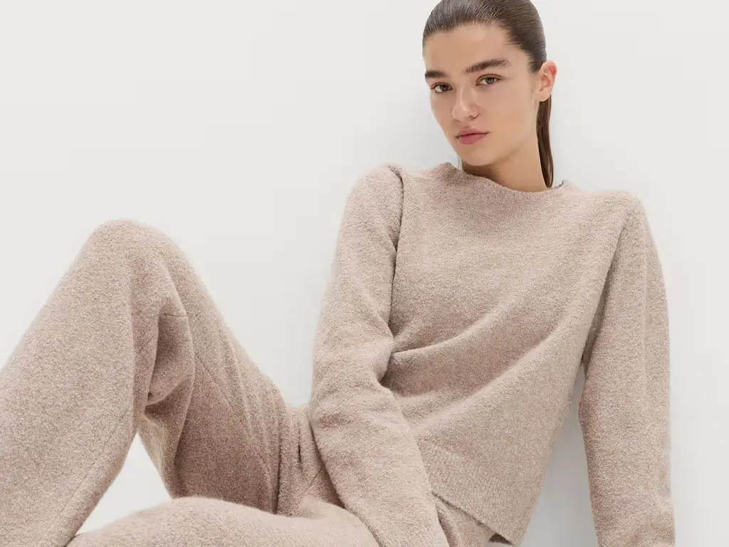 Woman in beige knitted top and trousers