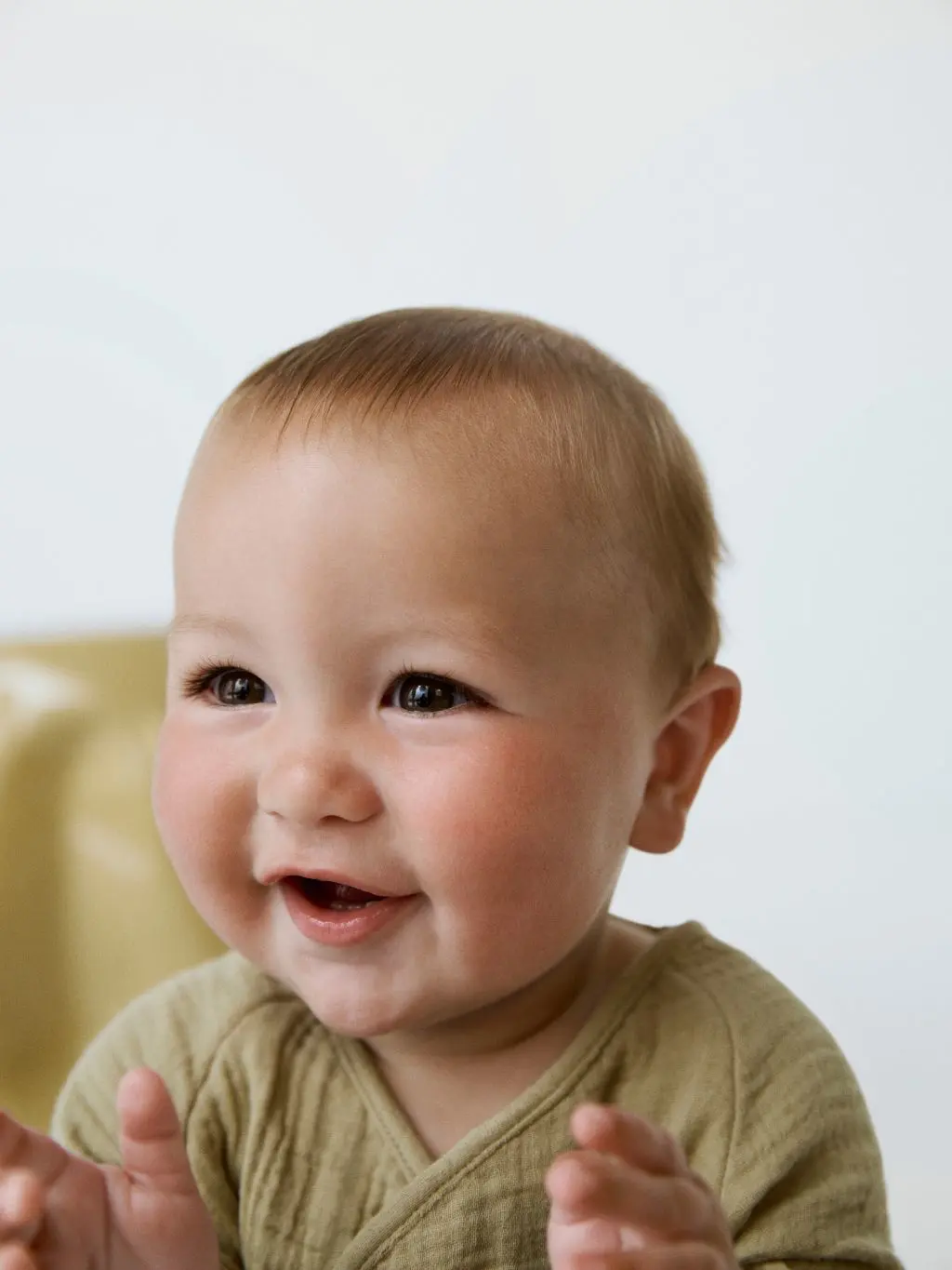A close up of a baby smiling and clapping
