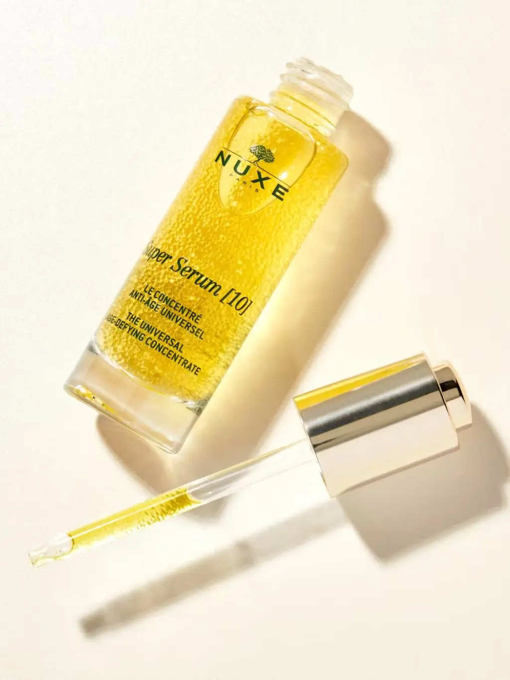 A bottle of Nuxe Super Serum on a light background
