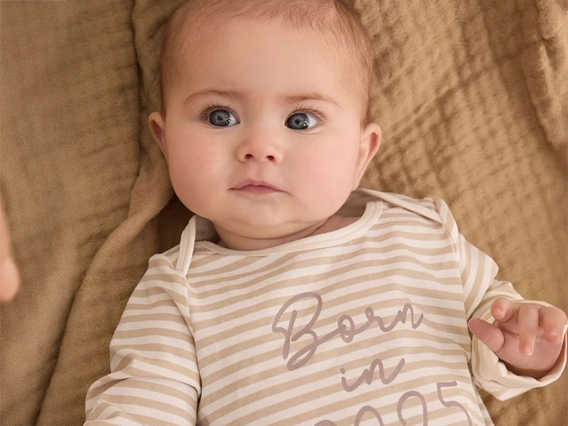 Baby wearing a striped babygrow